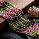 AAA natural Tourmaline round smooth bead strands with pink green watermelon shades in a styled gemstone display