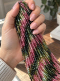 Natural Tourmaline 3mm round smooth beads held in hand showing bead size and watermelon pink green shades