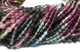 Close-up of natural Tourmaline 3mm round beads showing polished finish and pink green multicolor shades