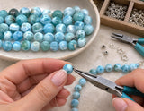 AAA natural Dominican Larimar gemstone beads being used with jewelry making tools to create handmade necklaces and gemstone jewelry