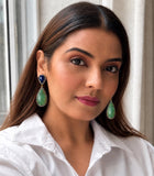 Emerald and blue sapphire long drop earrings worn on model showing statement size and gemstone color