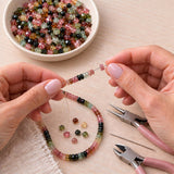 Natural tourmaline beads being used for handmade jewelry making with beading tools