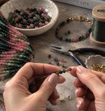 Natural Tourmaline 3mm round smooth beads in watermelon pink green shades being used with jewelry making tools to create handmade gemstone jewelry