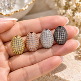 16x11.5mm oval micro pave beads held in hand showing gold, rose gold, platinum and gunmetal cubic zirconia color