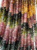 Close-up of faceted natural tourmaline beads in mixed pink, green and earthy gemstone shades