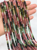 Natural multi tourmaline bead strands held in hand showing small faceted gemstone beads